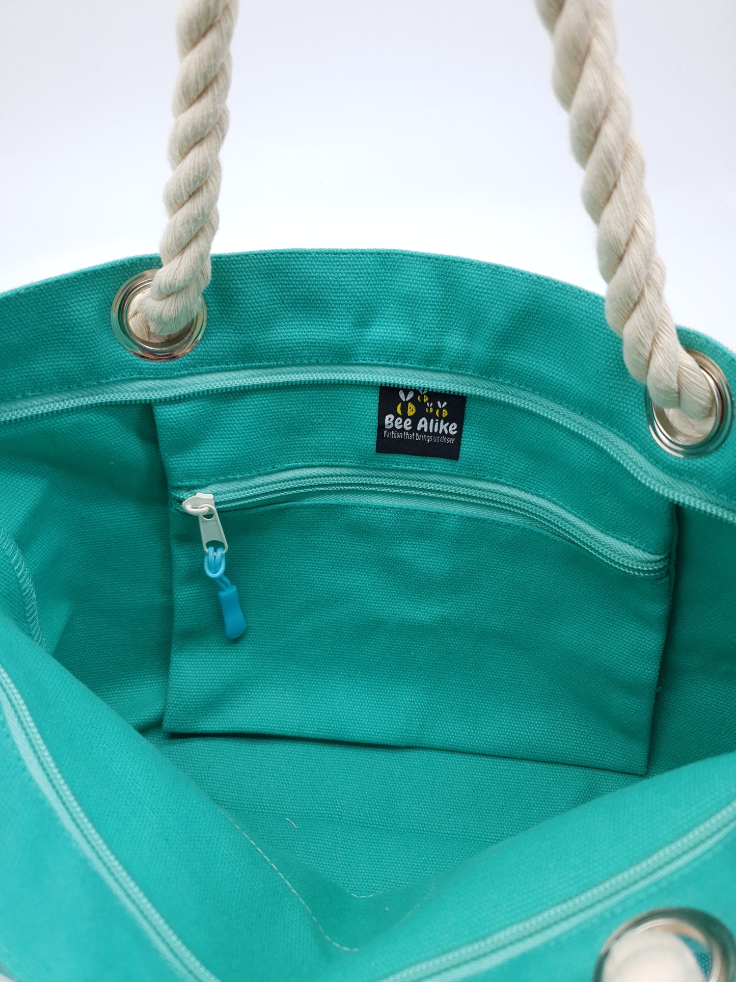 Inside picture of Teal tote bag, has a small zip pocket