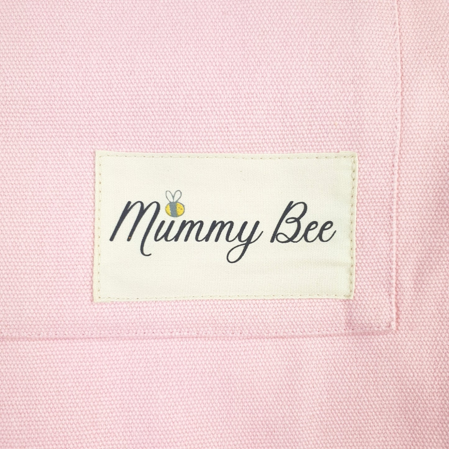 Close up picture of Adult Apron Logo, has Mummy bee print with small picture of a bee just above letter "u"