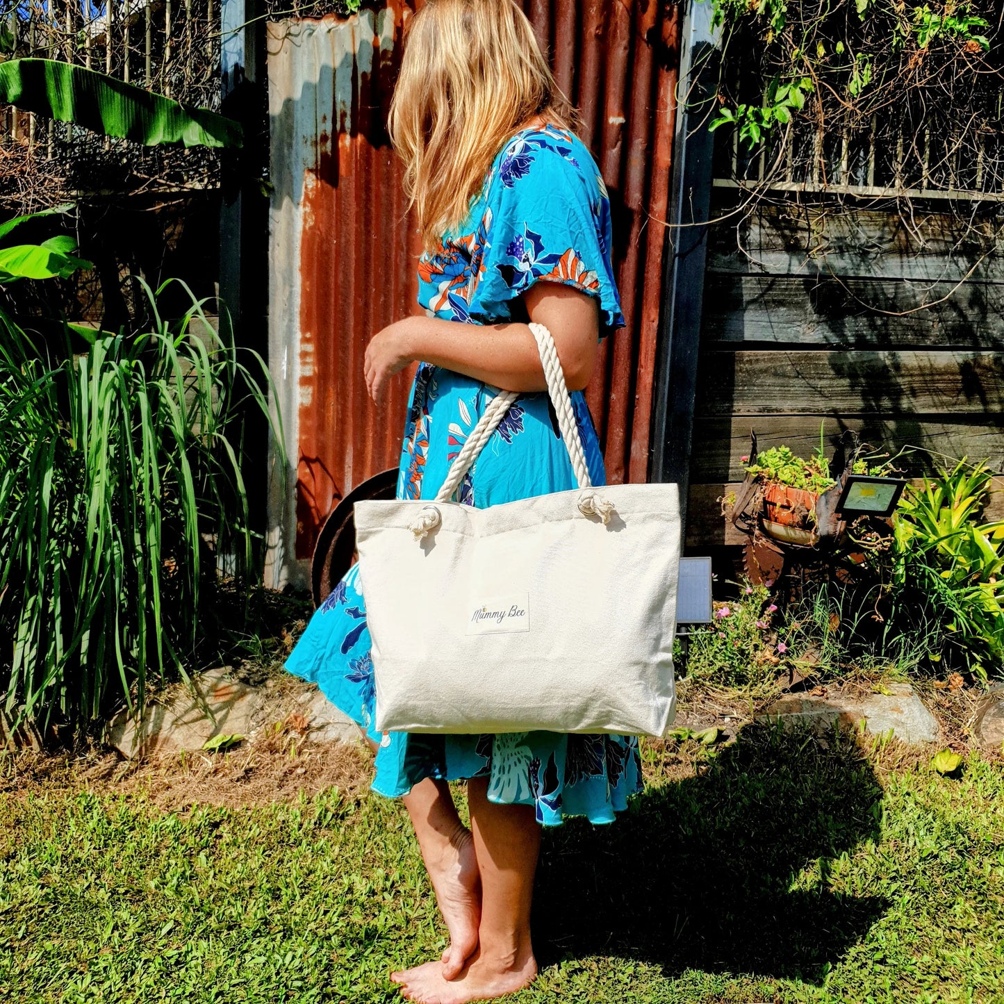 Woman holding adult tote bag in garden,