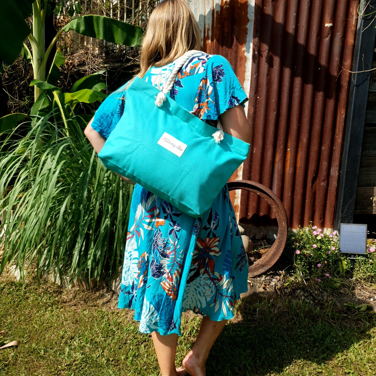 Woman holiding Teal Tote bag in the garden 